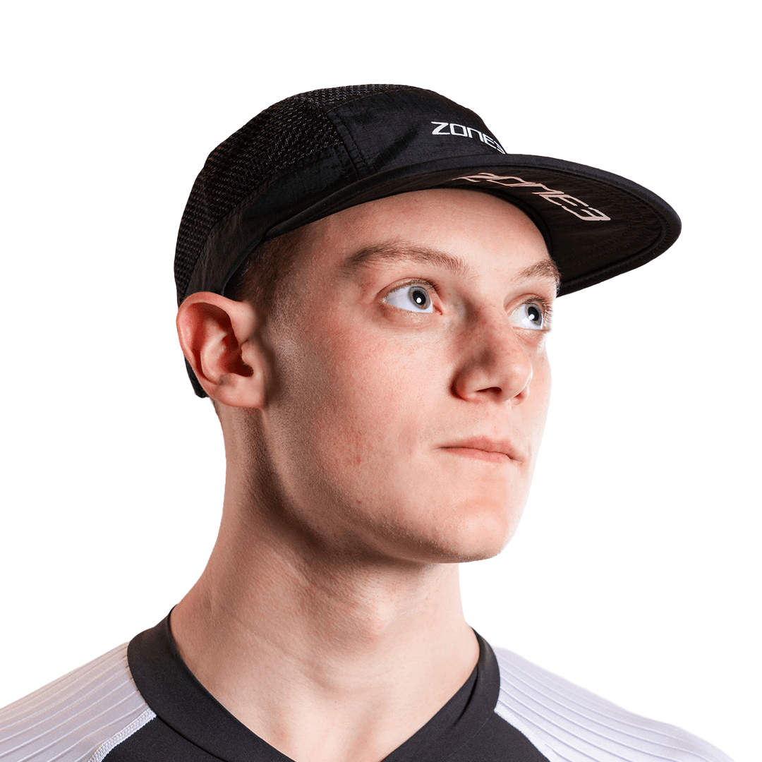 Person wearing a black zone3 mesh running cap with zone3 branding on a white background