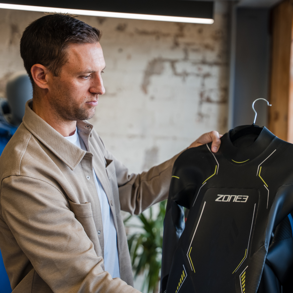 ZONE3 founder James Lock holding the 2025 Aspire wetsuit.
