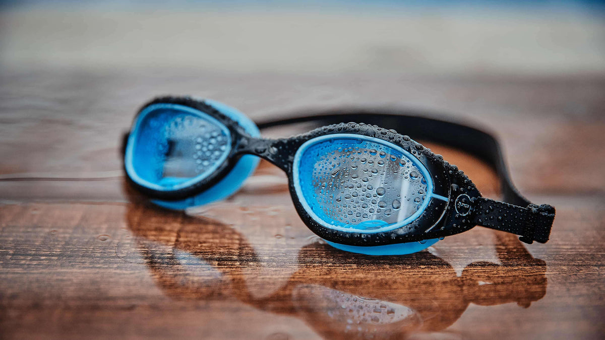 The black blue Attack goggles on wooden floor.