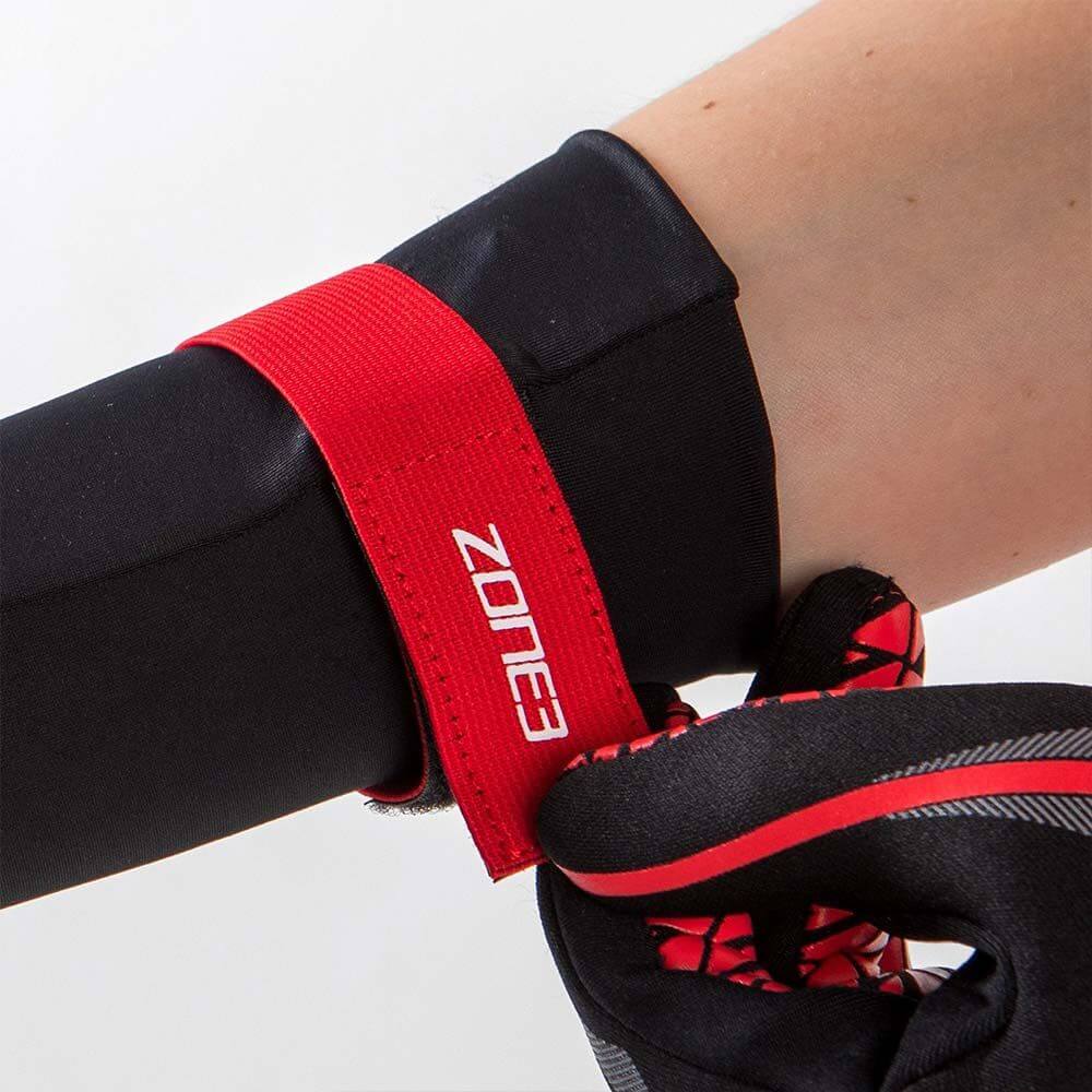 Person wearing ZONE3 neoprene gloves, showcasing the wrist strap for better insulation during cold water swimming.