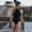 A woman wearing the Zone3 OWS Renew high neck swimsuit on a white background.