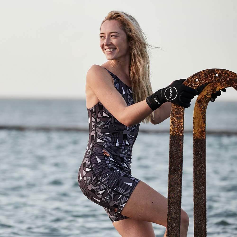 A woman wearing the Zone3 OWS Renew short leg kneeskin swimsuit on a white background.