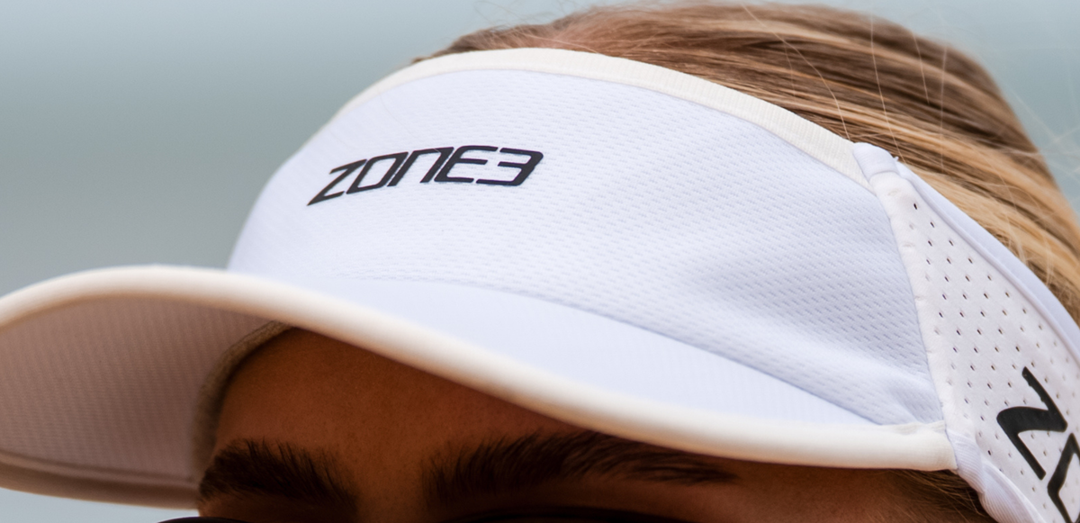 Close up of zone3 white running visor with a zone3 logo on a blurred background