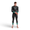 Front view of a man in a black Vision wetsuit with teal cuffs, looking down while adjusting his sleeve.